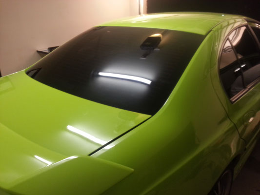 car window tinting installed on a green colour Ford Falcon sedan rear view