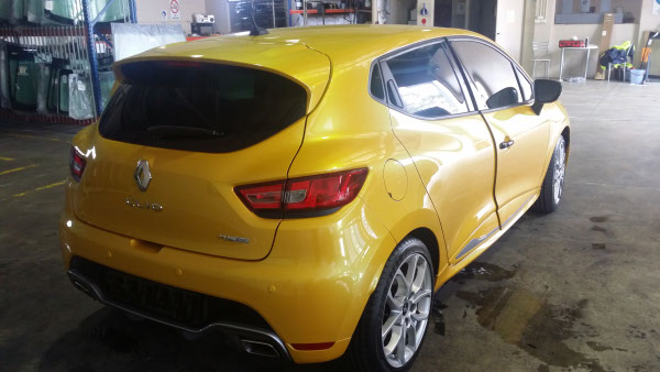 close up rear view of car window tinting completed on yellow colour Renault Clio