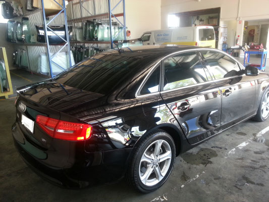 rear view black colour Audi A4 sedan car window tinted