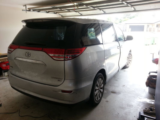 rear view of grey colour Toyota Tarago GLI van with darker tint on rear windows