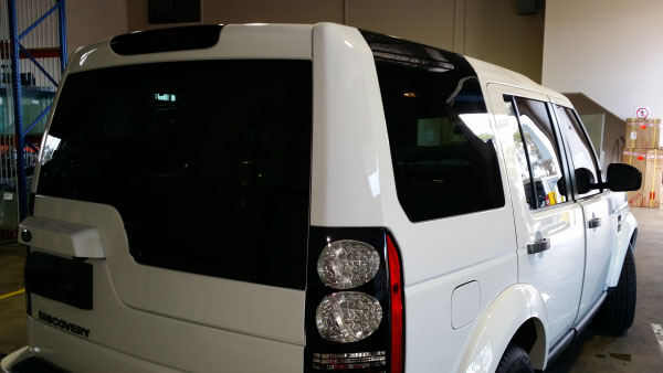 rear view white colour land rover discovery with car windows tinted by optimus tinting solutions